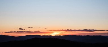 Güneşli, güneşli, tepeli, siluetli gün batımı.