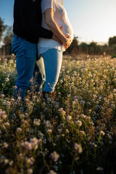 Jong Zwanger Paar Witte Bloemen Veld Met Zonsondergang Zonnestralen Achtergrond — Stockfoto