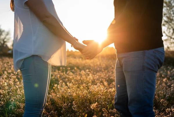 Giovane Coppia Incinta Tiene Mano Nel Campo Fiori Bianchi Con — Foto Stock