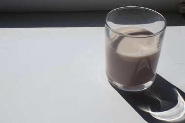 Beyaz arka planda bir bardak süt.