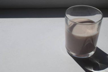 Beyaz arka planda bir bardak süt.