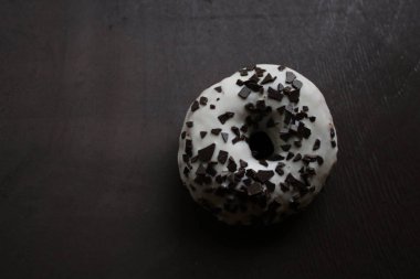 Siyah arka planda beyaz kremalı çörekler.