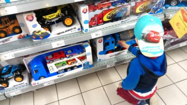 Portekiz, Algarve. Kasım 2019 civarı. Küçük çocuk süpermarkette satılık bir oyuncak seçiyor..