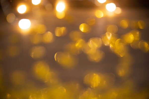 New Year and Christmas celebration. Abstract of blurry lights. Golden bokeh. The lights are out of focus.