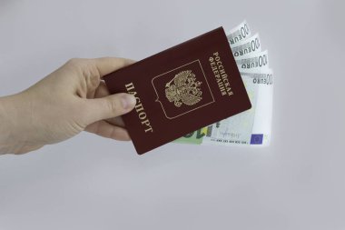Bir adamın elinde Rusya Federasyonu 'nun içinde 100 avroluk banknotlar bulunan yabancı bir pasaportu var. Seyahat. Yakın plan.