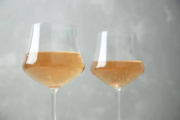 Dois copos de vinho laranja com taças de vidro em um fundo cinza — Fotografia de Stock
