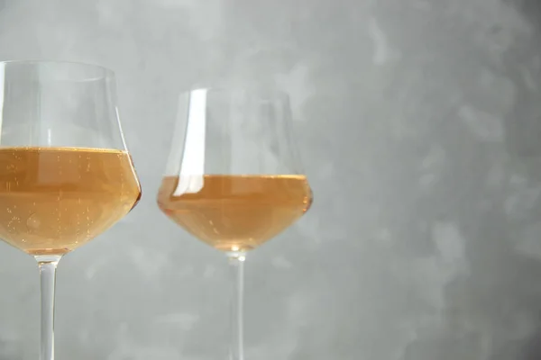 Due bicchieri di vetro con vino arancione. Primo piano. Un bicchiere è fuori fuoco. Fondo grigio — Foto Stock