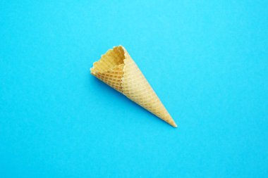 Boş gevrek waffle külahı, mavi arka planda dondurma kupası. Metin için yer.