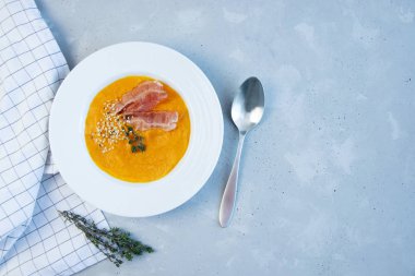 Gri arka planda pastırmalı balkabağı püresi çorbası. Boşluğu kopyala