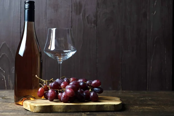 Una Bottiglia Vino Rosato Trova Tavolo Legno Accanto Bicchiere Vuoto — Foto Stock