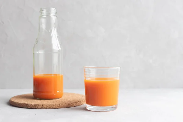 Glasflaska Med Morotsjuice Och Ett Glas Juice Står Bredvid Grå — Stockfoto