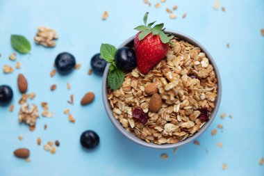 Kase, ev yapımı granola ya da fındıklı yulaf ezmesi ve taze çilek ve yaban mersini. Böğürtlen ve taneler yakınlarda.