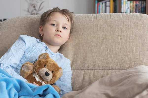 Avrupa görünümlü kahverengi saçlı üzgün ya da hasta bir kız evdeki bej bir kanepede oturuyor. Çocukluk depresyonu, yetişkinlerin anlayış eksikliği, ebeveynlerle çatışmalar