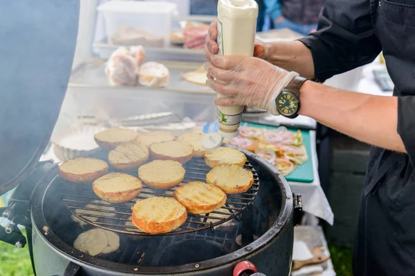 Chef fazendo hambúrgueres de carne ao ar livre na cozinha aberta evento festival internacional de comida . — Fotografia de Stock