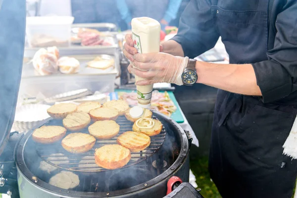 Chef fazendo hambúrgueres de carne ao ar livre na cozinha aberta evento festival internacional de comida . — Fotografia de Stock