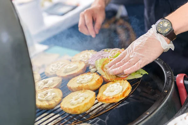 Chef fazendo hambúrgueres de carne ao ar livre na cozinha aberta evento festival internacional de comida . — Fotografia de Stock