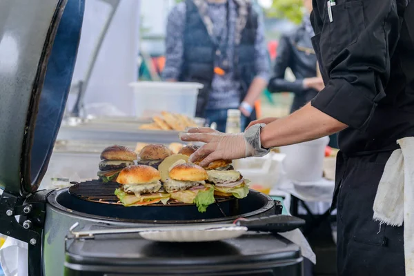 Chef fazendo hambúrgueres de carne ao ar livre na cozinha aberta evento festival internacional de comida . — Fotografia de Stock