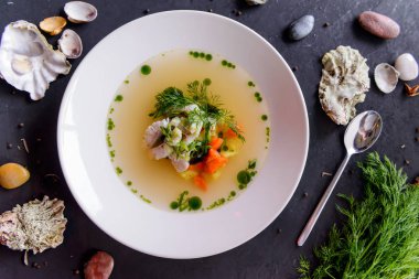 Deniz mahsulleri çorbası bir beton zemin üzerine beyaz bir tabak içinde