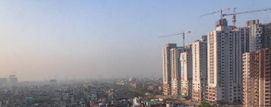 27 Mart 2017 'de Hindistan' ın Gaziabad şehrinde inşaat halindeki binalar ve havadaki sis üzerinde mekanik vinçler çalışıyor..