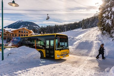 Kar üzerindeki turuncu kayak otobüsleri kayak bölgesi Schladming Dachstein, Avusturya ve Avrupa 'da yolu kapladı
