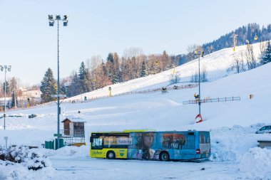 Avusturya sarı otobüs durağı, kayak bölgesi Schladming Dachstein - Hauser Kaibling. Karla kaplı dağları ve mavi gökyüzünü. 