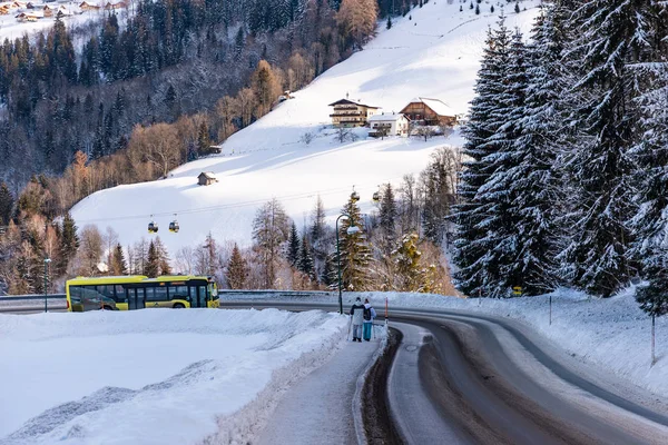 Gul skidbuss på vintersnötäckt väg vid skidområdet Schladming Dachstein, Österrike, Europa — Stockfoto