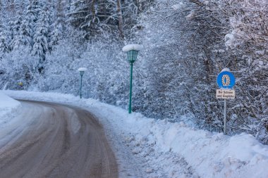 Trafik levhası, Bei Schnee ve Eisgltte. Mavi uyarı bilgisi: kar zinciri zorunluluğu. Kış zamanı, karla kaplı yollar, ağaçlar. Styria, Avusturya