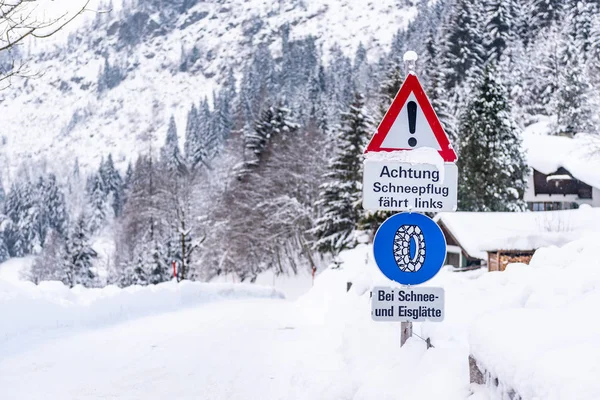 Trafik levhası, Bei Schnee ve Eisgltte. Mavi uyarı bilgisi: kar zinciri zorunluluğu. Kış zamanı, karla kaplı yollar, ağaçlar. Styria, Avusturya