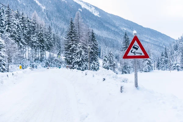 Kara buz tehlikesi - trafik işareti, uyarı, kış hizmetleri, Schladming Dachstein. Karla kaplı yollar ve ağaçlar. Avusturya, Europa
