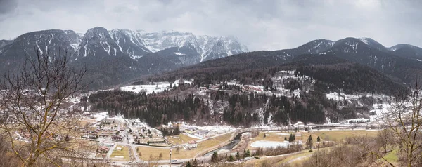 The panorama view of Dimaro - city in the popular ski region Val di Sole, Trento, Italy,  Europe. Snow covered alpine mountains  - Brenta Dolomites  at the background. Panorama view from a small town Deggiano.