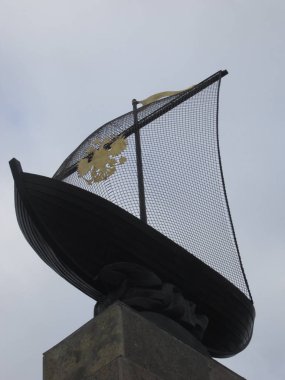          Iron sailboat with the coat of arms on a sail at the top of the column