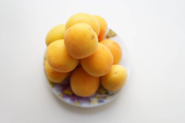        Ripe yellow apricots on a small porcelain saucer                                                                    