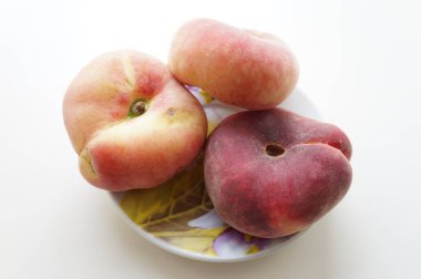 Ripe juicy peaches on a small porcelain plate