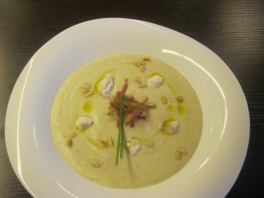 Beyaz tabakta yeşillik ve fıstık ile yulaf ezmesi.