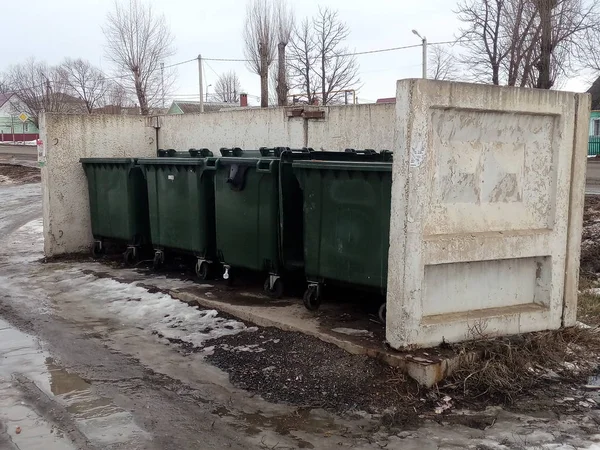 Green plastic containers for garbage collection on an insulated concrete slab site