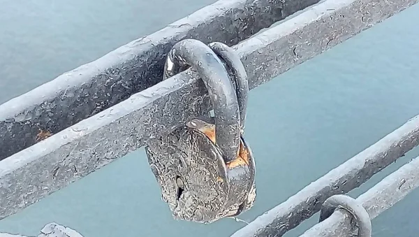 The iron lock locked on a key on a metal pipe