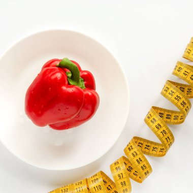 Hayat tatlı biber, bir tabak ve bir santimetreden ibarettir. Beyaz arka plan. Diyet kilo vermene yardımcı olur..
