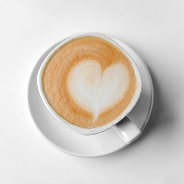 Süt köpüğünden yapılmış kalbi olan beyaz bir fincan kahve. Beyaz bir masada bir fincan duruyor. Yukarıdan bak. İzole edilmiş.