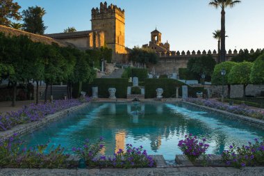 Cordoba, İspanya, 26 Eylül 2017: Cordoba, Endülüs, İspanya 'daki Alcazar de los Reyes Cristianos' un resmi bahçesi ön planda süslü bir gölet ve arka plandaki ana bina,