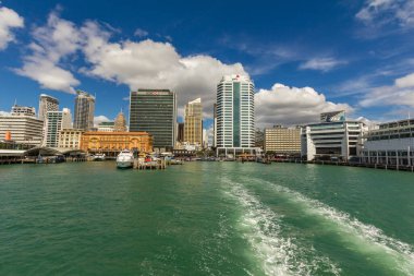 Teknenin Auckland Limanı 'ndan ayrılırken arka planda şehir silüeti olan bir feribotun arkasındaki manzara..