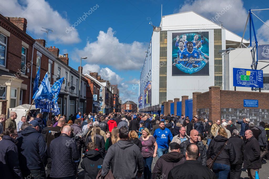 Everton, Liverpool, UK, April, 17, 2016: Crowds supporters gather at Everton Football Club for a premiership game, flags and scarfs in the Everton colours can be seen, against a bright blue sky