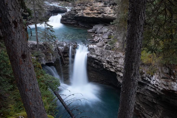 Водопад вдоль Каньона Джонсона в Национальном парке Банф, Канада, подвергся длительному воздействию, чтобы сгладить воду — стоковое фото
