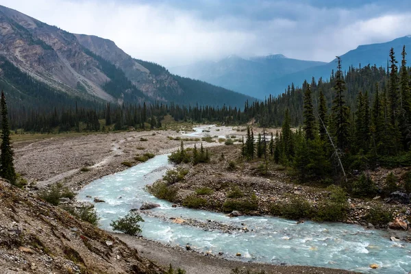 Bow River väver sig genom ett stenigt bergigt landskap, floden som transporterar smältvatten från Bow Glacier — Stockfoto