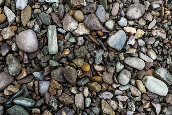 Die Textur eines flachen Flusssteins. Kieselstein Hintergrundbild — Stockfoto