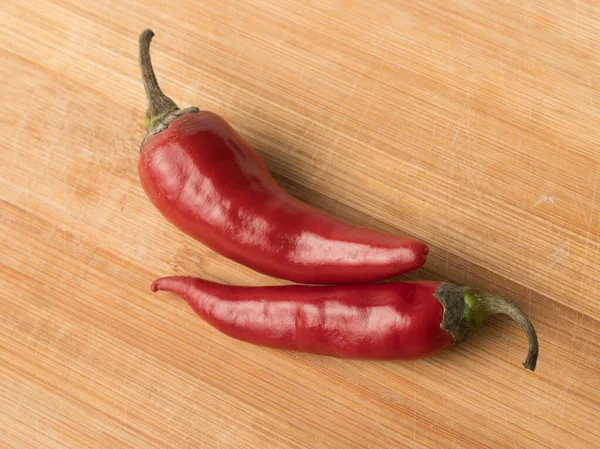 Imagen de fondo de chiles rojos picantes en un bo de corte de madera — Foto de Stock