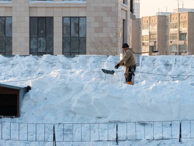 Hard work to remove snow from the roof of a building