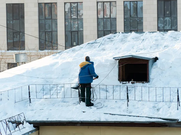 Těžká práce na odstranění sněhu ze střechy budovy — Stock fotografie