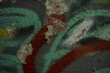 Eski beton duvarın dokusu boya ile kaplıdır. Çatlamış eski boya nın dokusu. Bir kask boyalı duvar bir arka plan görüntüsü. Beton duvardaki eski grafiti yakın mesafeden vurulmuş. Grafik kaynakları soyut dokulu arka plan.