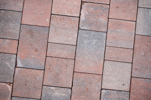 Background image of neatly laid paving slabs. Wallpaper. Substrate for text. Detailed texture of a tiled path. Paving slabs in the exterior. The surface of the road for pedestrians.