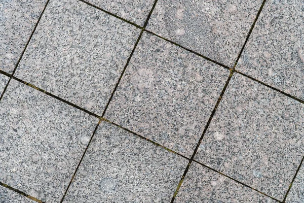 Background image of pavement surface. Wallpaper. Substrate for text. Detailed texture of a pedestrian walkway with paving tiles. Paving slabs in the exterior.